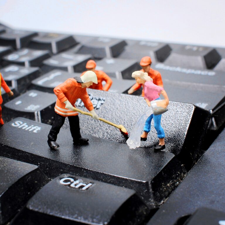 Miniaturowe postacie czyszczą klawisze klawiatury.