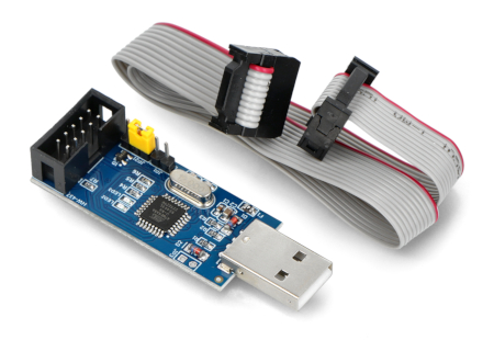 Programator AVR leży na białym tle wraz z dołączoną do zestawu taśmą..